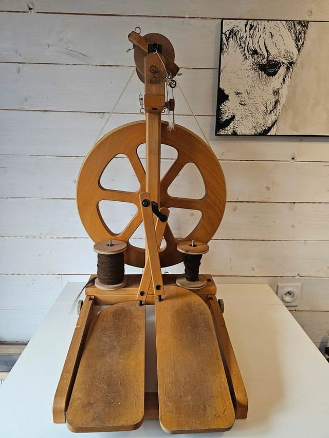 Le rouet en bois de Laetitia et ses bobines de laine d'alpaga filée main, dans l'atelier